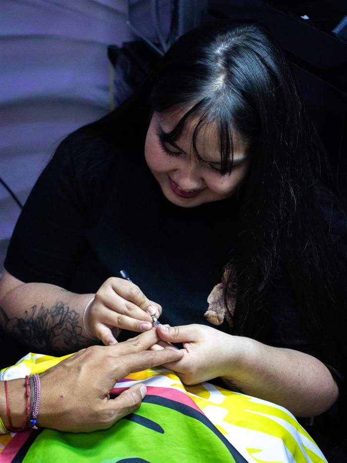 Especialista de ROOR sonriendo mientras hace una manicura